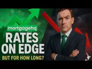 A man looking sternly into the camera with text next to him "Rates on edge but for how long?", indicating this video is about interest rates